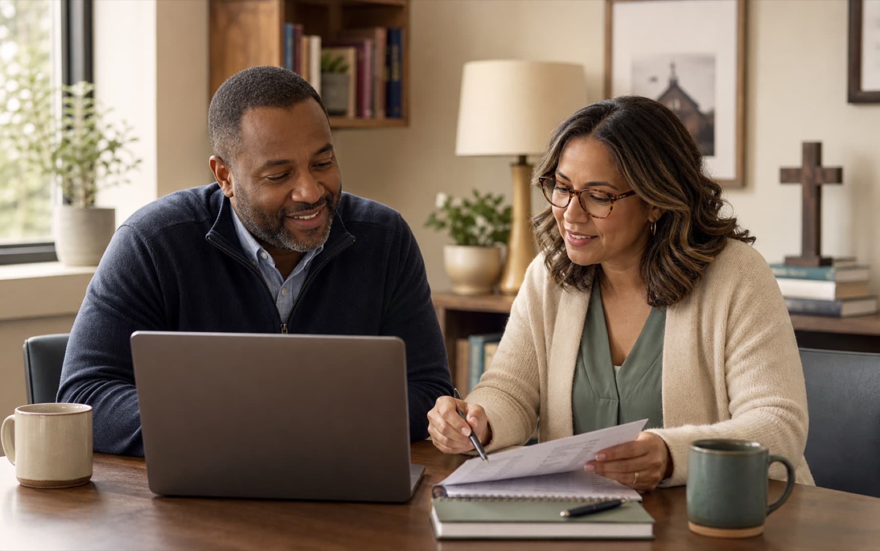 A pastor and church administrator reviewing TendWell together in a warm church office.